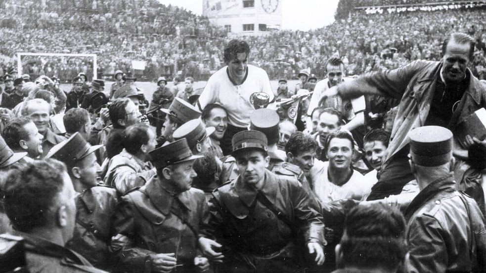 Es war das Wunder von Bern: Am 4. Juli 1954 besiegte die westdeutsche Fußball-Nationalmannschaft im WM-Finale Ungarn mit 3:2 und wurde zum ersten Mal Weltmeister. WM-Held Fritz Walter wurde mit dem Pokal in der Hand auf Händen getragen. Foto: Archiv dpa