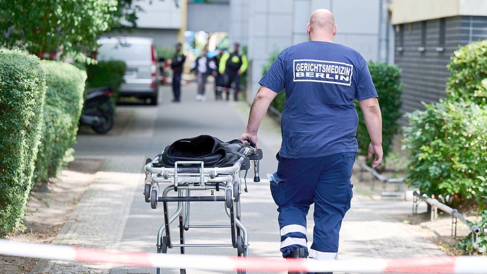 Ein Mann von der Gerichtsmedizin schiebt eine Bahre in der Nähe des Fundortes des toten Neugeborenen. Foto: Annette Riedl