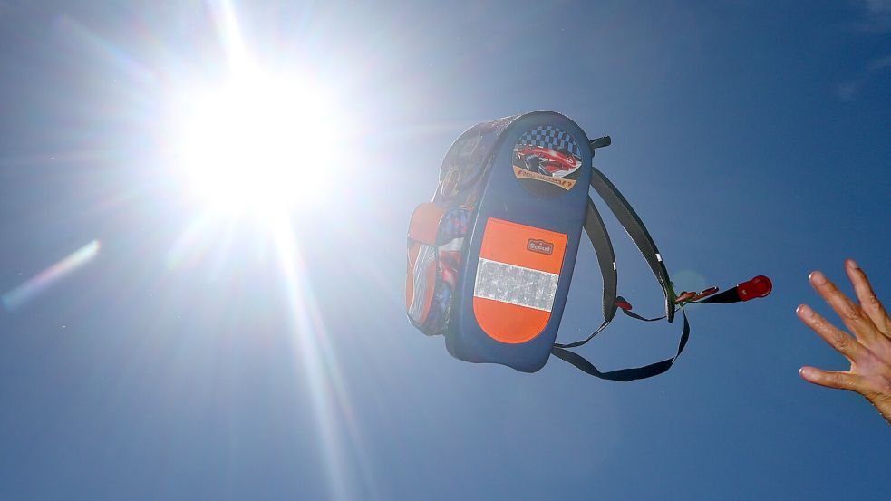 Ein Ranzen wird bei hellem Sonnenschein geworfen (Symbolfoto). Foto: DPA