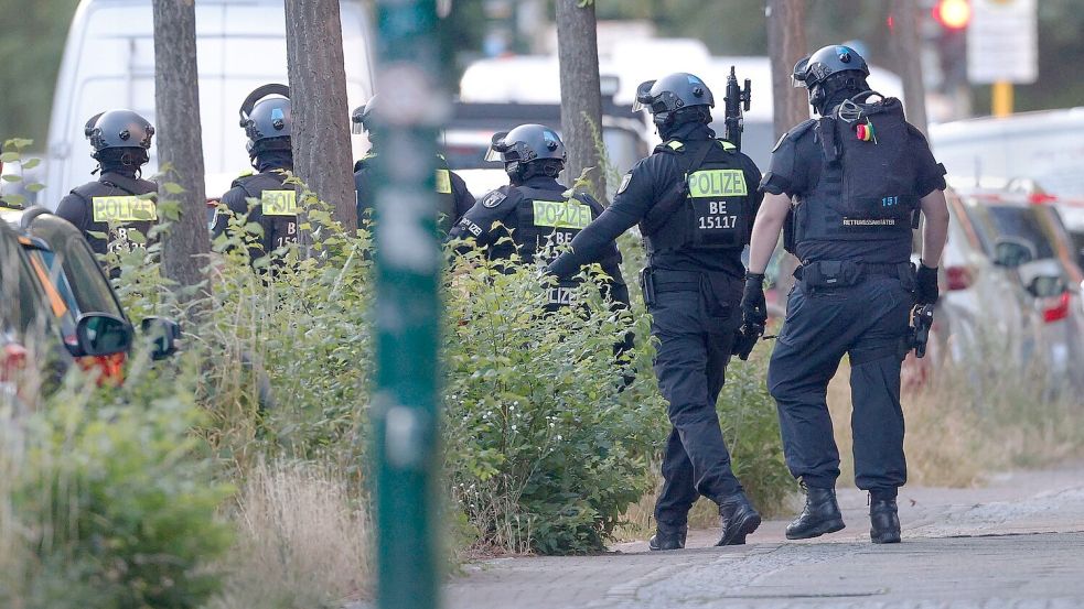 Polizisten sind in der Nähe von einem Supermarkt im Einsatz. Foto: Carsten Koall/dpa