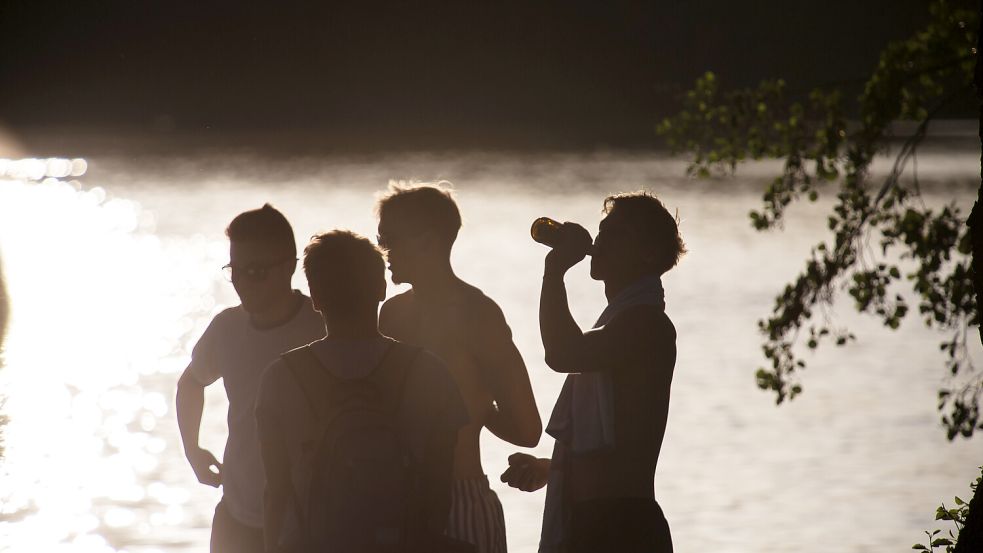Eine Gruppe junger Männer an einem Badesee. Foto: picture alliance/ Andreas Bastian