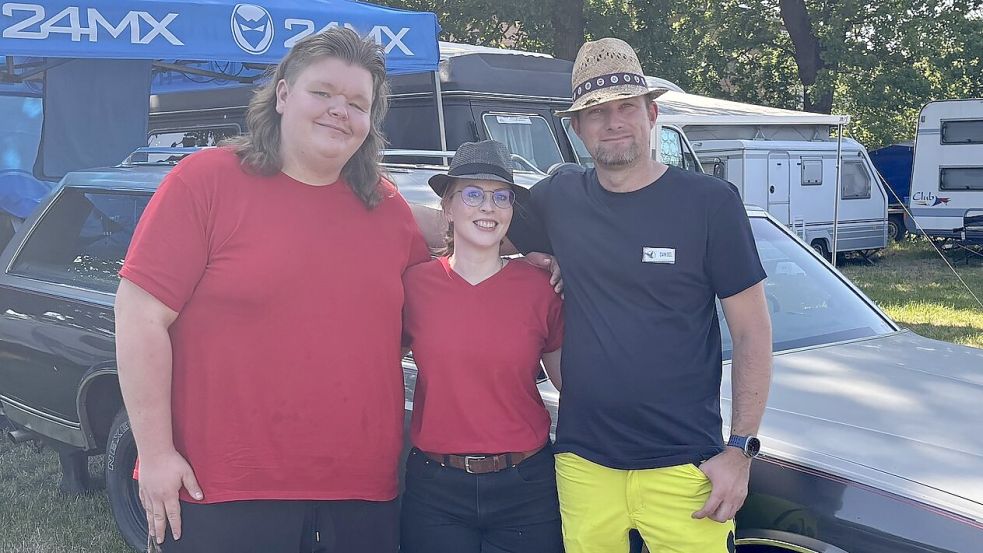 Der Vereinsvorsitzende Renke Adomat (links), Mitorganisatorin Annika Harms und das am weitesten angereiste Vereinsmitglied Daniel vor seinem Chevrolet Caprice Kombi. Foto: Lasse Paulsen