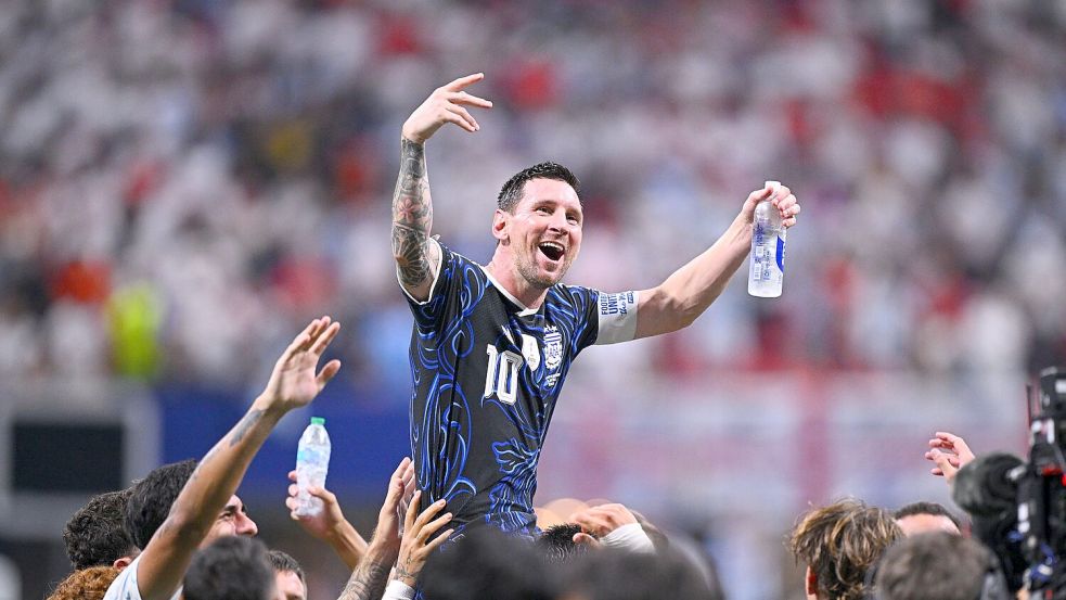 Lionel Messi wird auf Schultern getragen. Foto: Tom Weller/dpa