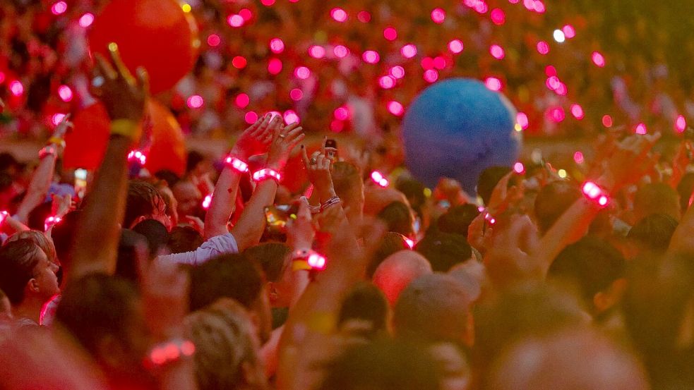 Zuschauer tragen 2024 bei einem Konzert leuchtende Armbänder, die laut Coldplay pflanzenbasiert und kompostierbar sind. (Archivbild) Foto: Henning Kaiser