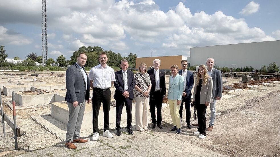 Firmengründer Johann J. Köster und seine Frau Albertine Mansholt-Köster vor der Baugrube für die neue Werkshalle und umringt von ihren Mitarbeitern René Jakobs (von links), Malte Fritz, Thorge Westdörp sowie Ann-Christin Schramm (Zweite von rechts) und den Gästen Saskia Buschmann, Niklas Müller, und Dr. Frank Puchert. Foto: Karin Böhmer
