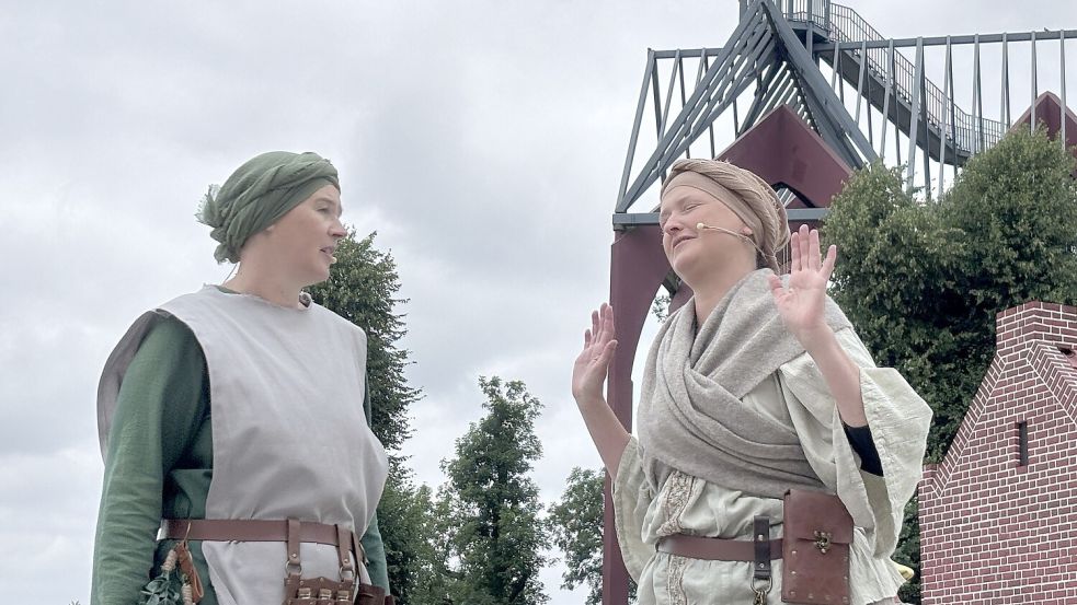 Zwei Marktfrauen tratschen in einer Szene über gutgläubige Kundschaft. Im Hintergrund ragt die Darstellung der Klosterstätte als passende Kulisse in die Höhe. Foto: Christin Wetzel