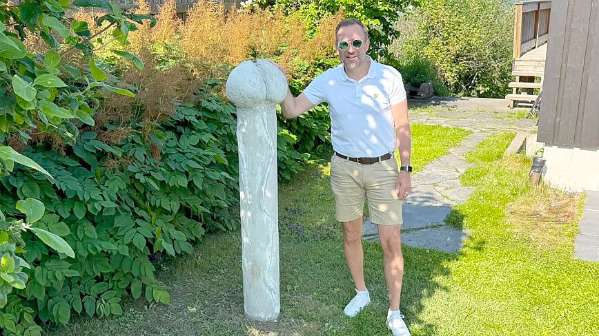 Petter Bjørstad gut gelaunt neben der Penis-Skulptur in seinem Garten. Foto: Privat