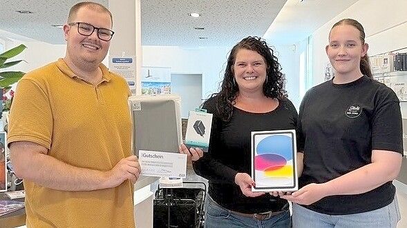 Glückwunsch zum neuen iPad: ON-Digital-Abo-Manager Tizian Dunkmann übergibt Heike Bikker ihren Preis, der einen Wert von 750 Euro besitzt. Tochter Lotte Bikker freut sich mit. Foto: Ariana Petersen