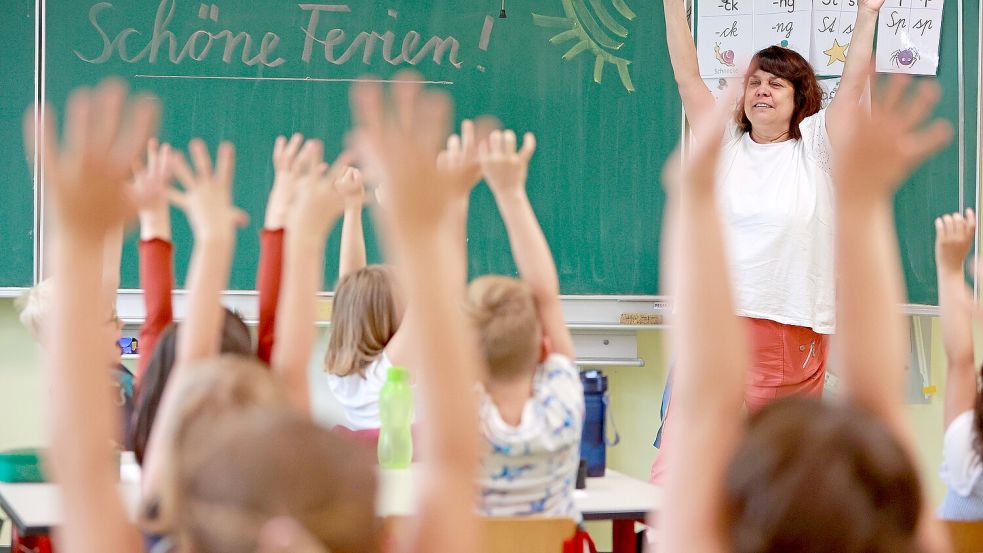 Schüler einer ersten Klasse freuen sich auf die Ferien. Foto: DPA