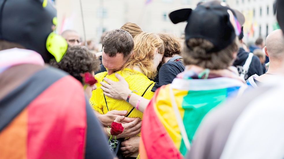Nach dem Anschlag am Rande des CSD in Berlin trauern viele Menschen, unter anderem vor dem Brandenburger Tor. Foto: Christoph Soeder/dpa