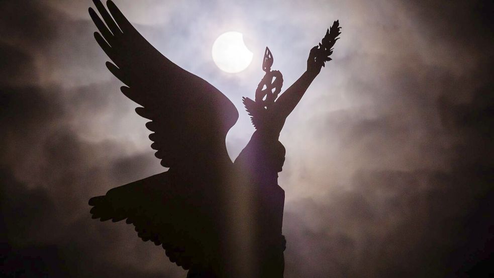 Die bislang letzte partielle Sonnenfinsternis über Deutschland war am 29.3.25 zu sehen - wie hier bei der Siegessäule in Berlin. (Archivbild) Foto: Christoph Soeder/dpa