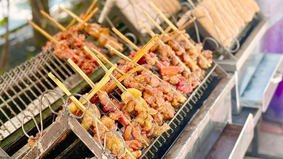 In Deutschland wäre das eher ein Mittagessen - aber die Thais lieben marinierte Schweinespieße (Moo Ping) schon zum Frühstück. Foto: Carola Frentzen/dpa