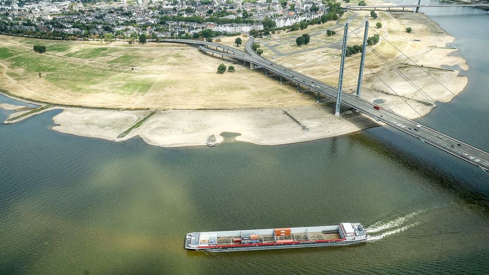 Einfache Rechnung: Wenn wenig Wasser im Rhein fließt – wie hier bei Düsseldorf –, können Binnenschiffe auch weniger Ladung transportieren. Darunter leiden nicht nur Öl-, Chemie- und Stahlindustrie massiv. Foto: Oliver Berg/dpa