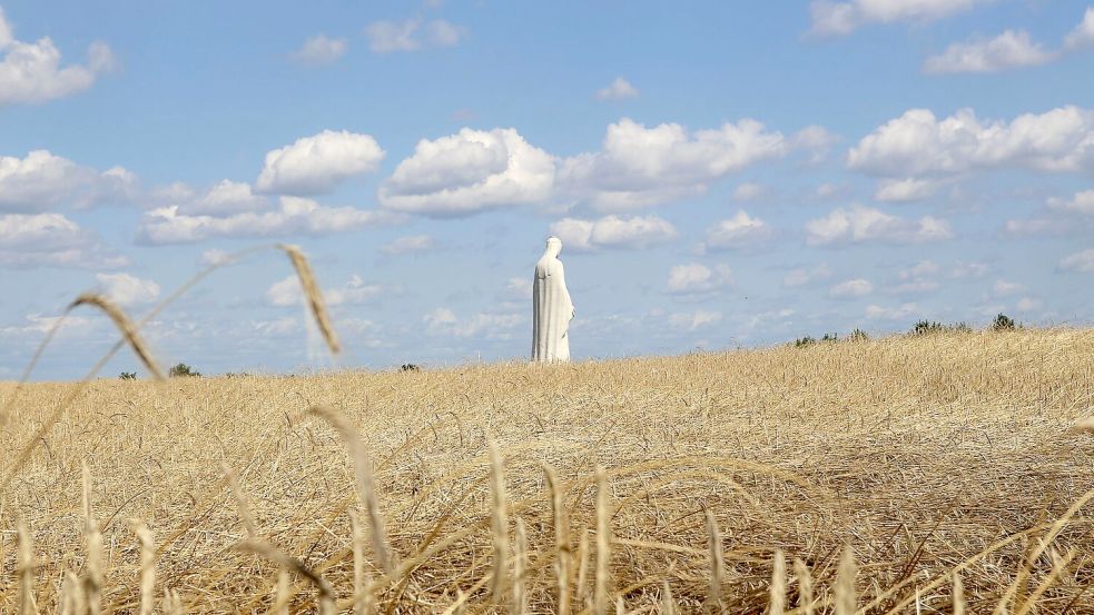 Die Marienfigur ist zwischen Kornfeldern von weitem zu sehen. Foto: Doris Heimann/dpa