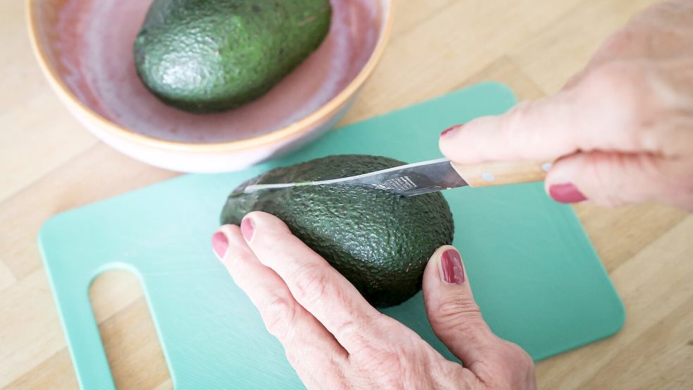 Die Avocado sollte beim Schneiden nicht in der Hand gehalten werden. Foto: Christian Charisius