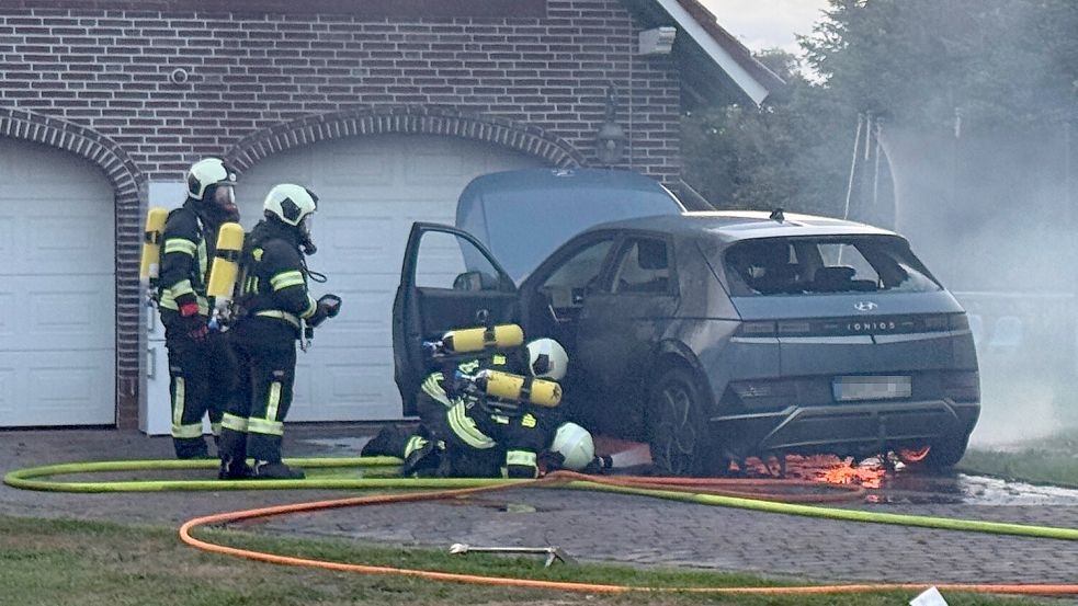 Das brennende Elektrofahrzeug war in unmittelbarer Nähe einer Garage abgestellt. Atemschutzgeräteträger bekämpften das Feuer von zwei Seiten. Foto: Sönke Geiken, Stadtfeuerwehr Aurich