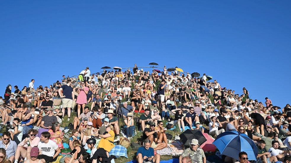 Menschen betrachten eine partielle Sonnenfinsternis am Olympiaberg im Münchner Olympiapark. Foto: Felix Hörhager