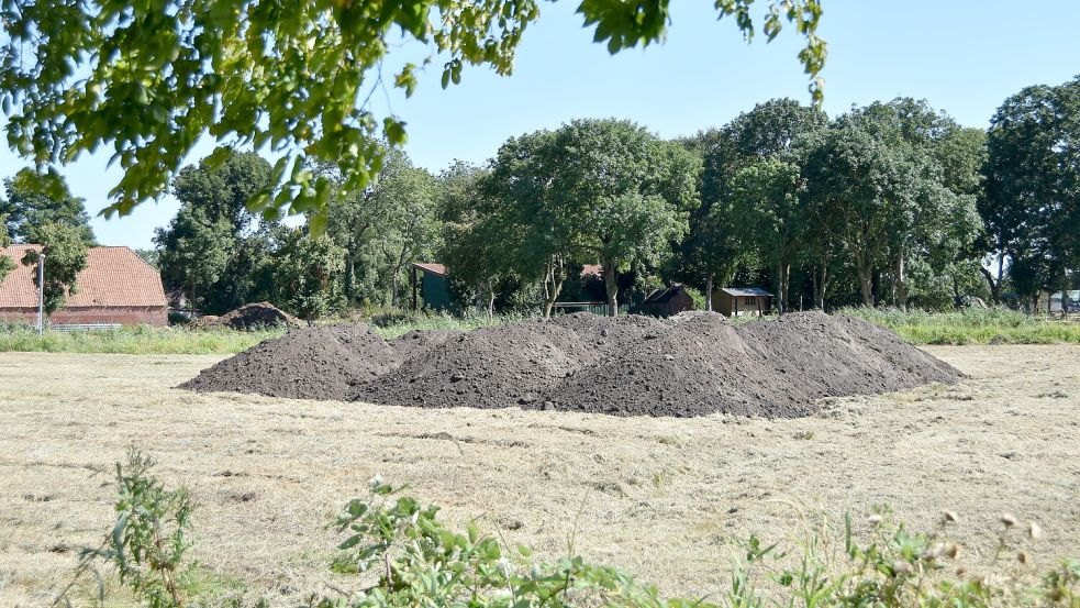 Mehrere Lastwagen-Ladungen Erdboden wurden auf der gemähten Grünfläche abgeladen. Foto: Thomas Dirks