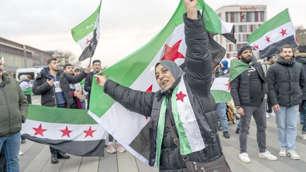 Eine Syrerin feiert im Dezember 2024 in Duisburg den Sturz des Assad-Regimes. Foto: imago/Jochen Tack