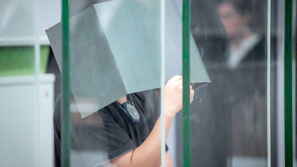 Der Angeklagte hält sich zum Beginn des Prozesstages im Kriminalgericht Moabit einen Aktenordner vors Gesicht. (Archivbild) Foto: Soeren Stache