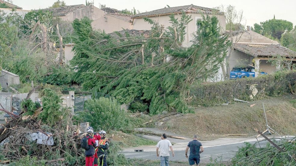 Nach dem Tornado untersuchen Einsatzkräfte die Häuser in der Gemeinde. Foto: Idriss Bigou-Gilles/AFP/dpa