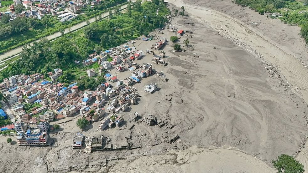 Beschädigte Häuser standen gefährlich nahe an den angeschwollenen, mit Treibgut verstopften Ufern des Trishuli-Flusses. Der Bhotekoshi ist ein Quellfluss des Trishuli. Foto: Niranjan Shrestha/AP/dpa