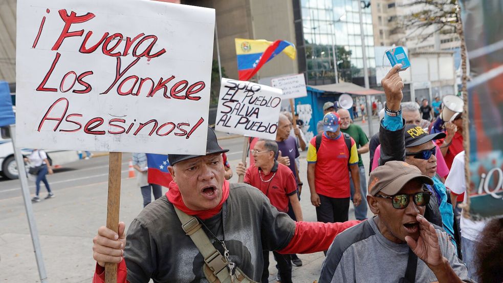Ein Mann hält bei einer Demonstration gegen das Abkommen ein Schild mit der Aufschrift auf Spanisch: „Yankees raus, Mörder“. Foto: Pedro Mattey/AP/dpa