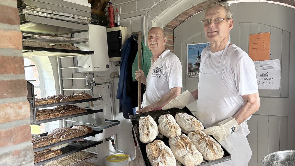 Knusprig, knuspriger, Krustenbrot: Gemeinsam holen Claus-Dieter Freimuth und Bernhard Schwitters die heißen Brote aus dem Ofen. Foto: Mieke Matthes