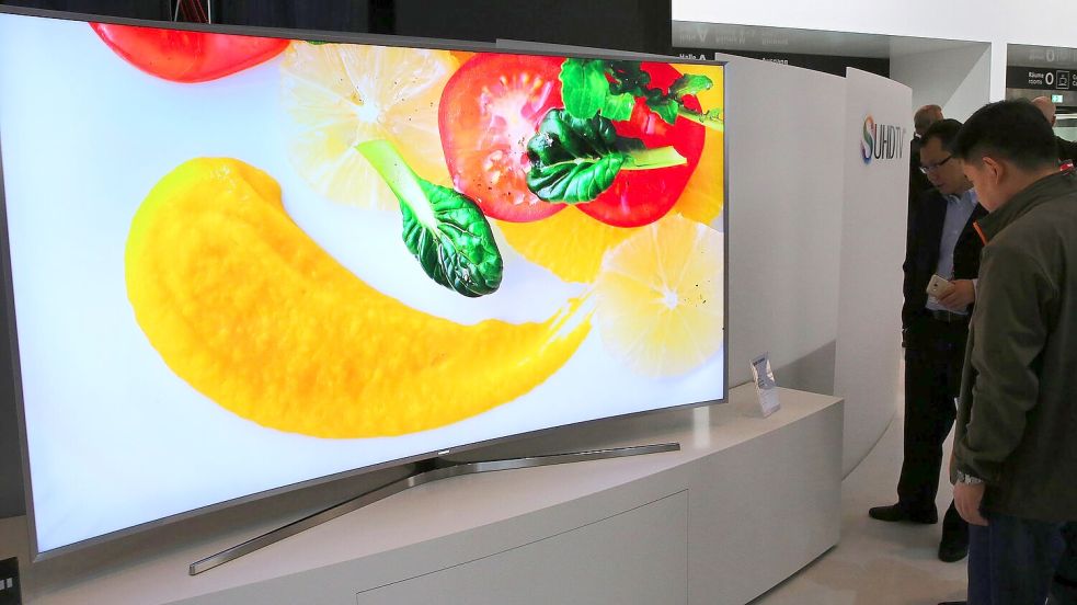Besucher betrachten auf der IFA 2015 hochauflösende gebogene Flachbildschirme von Samsung. Foto: Wolfgang Kumm/dpa