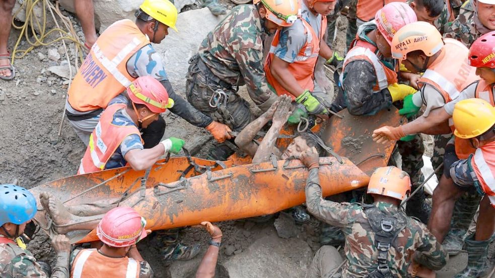 Soldaten ziehen einen Mann lebend aus einem Tunnel eines Wasserkraftwerks. Foto: Uncredited/Nepal Army/AP/dpa