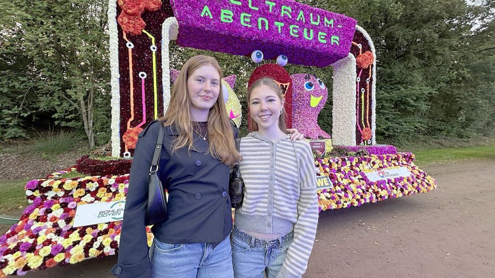 Rund um den Sportplatz präsentieren sich beim Dämmerschoppen im Stadion des VfB Germania die Korsowagen. Das ist der Lieblingswagen von Lena Tjarks und Luisa Scheele (von links). Foto: Nicole Böning