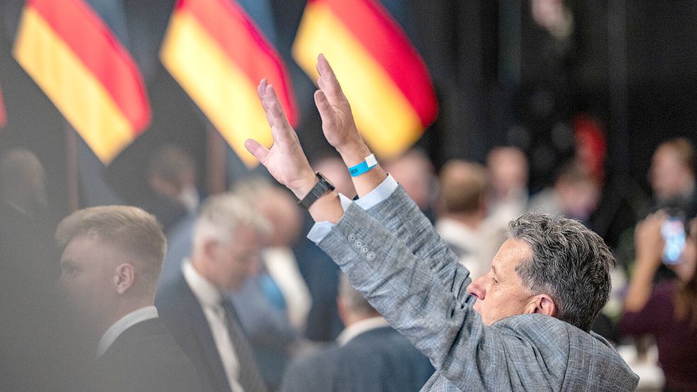 Als die ersten Zahlen auf dem Bildschirm erscheinen, fliegen auf der Wahlfeier der AfD im Alten Theater Magdeburg die Hände in die Luft. Dieses Ergebnis hat sogar die Partei selbst überrascht. Foto: IMAGO/Chris Emil Janssen