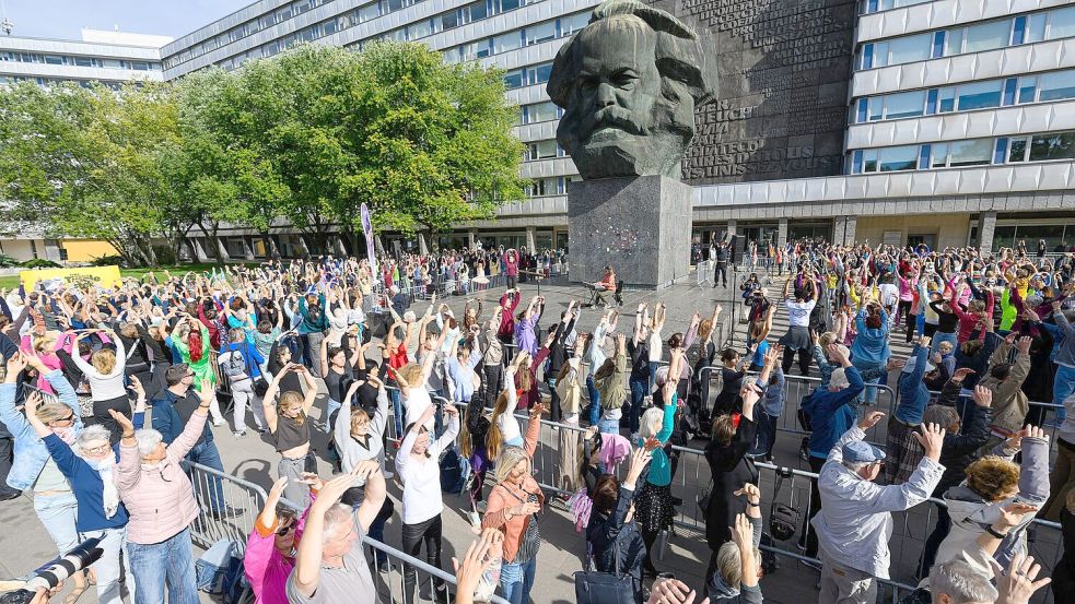 Tanz den Karl Marx: Bei einem Rekordversuch tanzen die Teilnehmer am Marx-Denkmal in Cottbus. Foto: Hendrik Schmidt/dpa