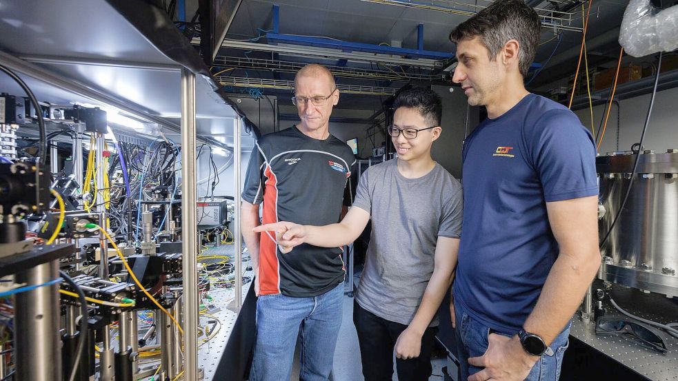 Wissenschaftler der National University of Singapore - im Bild von links nach rechts Teamleiter Murray Barrett, Michael Lee und Kyle Arnold - haben die aktuell genaueste Atomuhr der Welt gebaut.  Foto: ---/Centre for Quantum Technologies/National University of Singapore/dpa