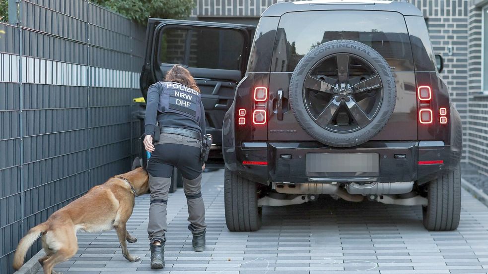 Eine Polizeibeamtin mit ihrem Diensthund durchsucht einen Pkw eines Mannes aus dem Umfeld der Hells Angels. Foto: Christoph Reichwein/dpa