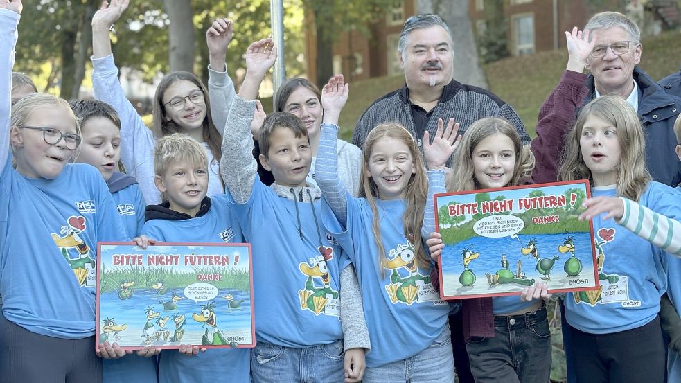 Cartoonist Stephan „Hösti“ Höstermann (zweiter von rechts) und Aurichs Bürgermeister Horst Feddermann weihten gemeinsam mit Schülern der Realschule Aurich und der Oberschule Herrentor Emden die neuen Schilder ein. Foto: Eva van Loh