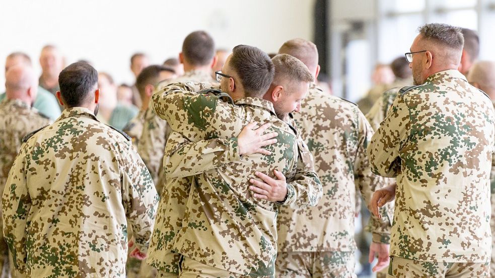 Soldaten umarmen sich nach ihrer Rückkehr aus dem Irak. Foto: Michael Matthey/dpa