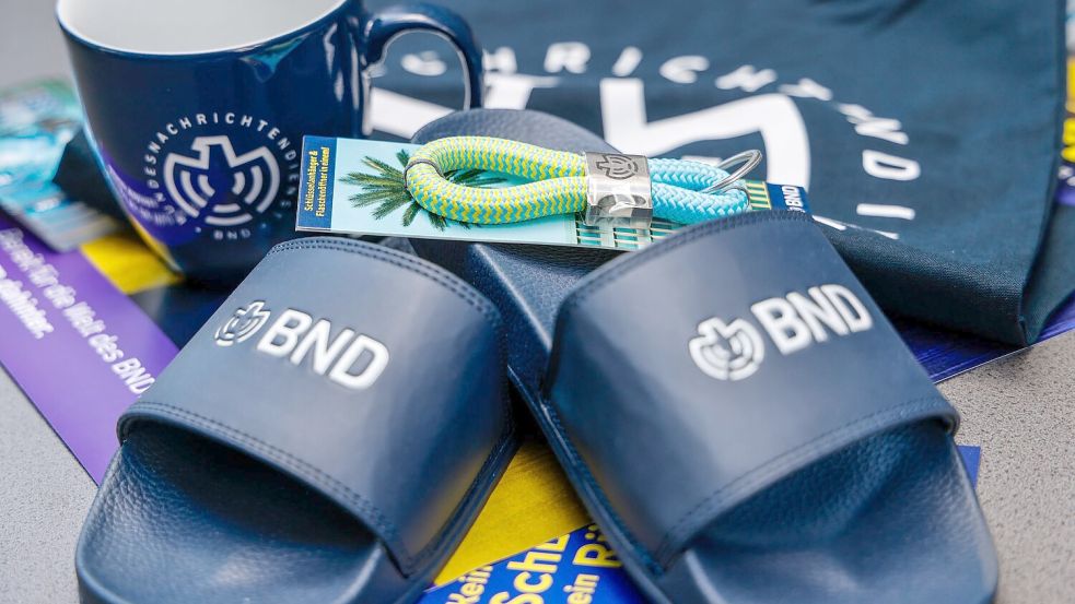 Im Merchandise-Shop gibt es T-Shirts und auch Badelatschen mit BND-Logo.  Foto: Focke Strangmann/dpa