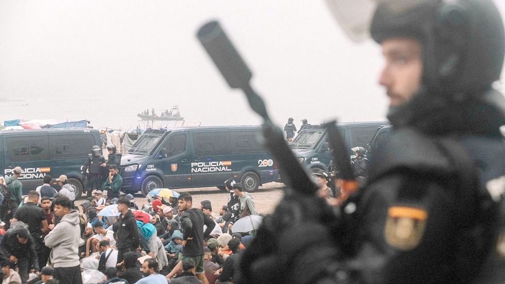 Migranten wurden in Ceuta von starken spanischen Polizeikräften von einem Hüttenlager am Strand fortgebracht.  Foto: Fabian Suspensivo/ZUMA Press Wire/dpa