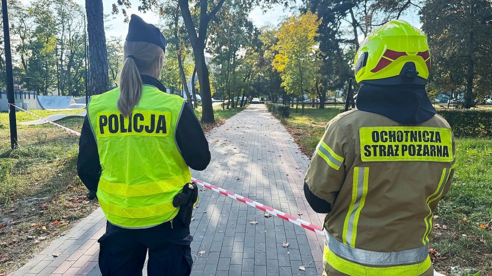 Eine Polizistin und ein freiwilliger Feuerwehrmann sind am Tatort eines Messerangriffs an einer Berufsschule. Foto: Rafal Niedzielski/AP/dpa