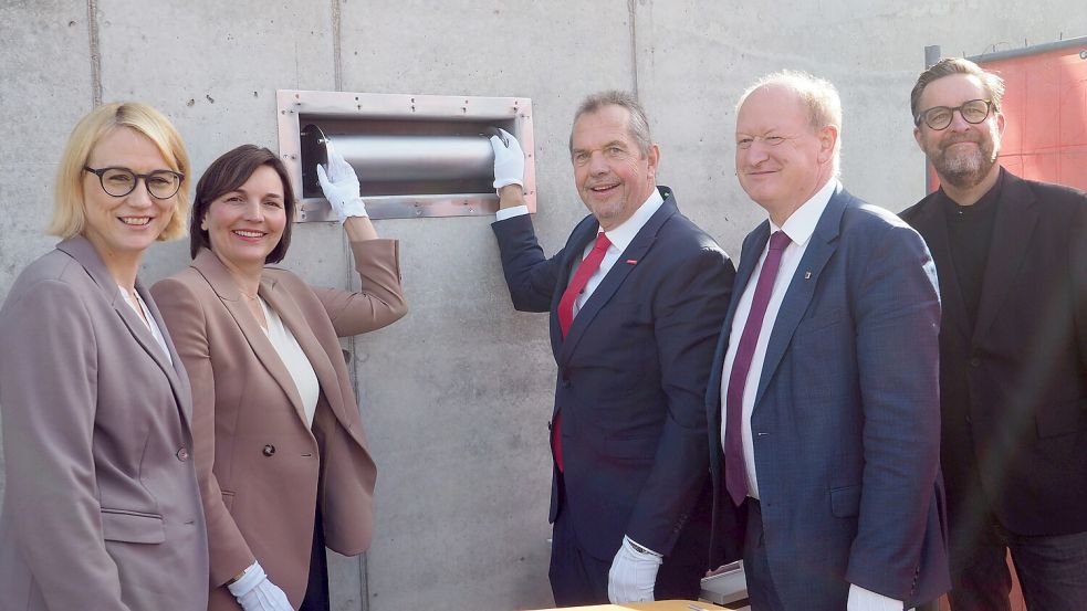 Die Zeitkapsel wird in das Fundament des Gebäudes eingelassen. Auf dem Bild: Katharina Pötter (Oberbürgermeisterin Osnabrück), Mareike Wulf (Parlamentarische Staatssekretärin bei der Bundesbildungs- und -familienministerin), Andreas Nünemann (HWK-Präsident), Reinhold Hilbers (Landtagsabgeordneter Grafschaft Bentheim) und Alexander Pick (Architekt). Foto: Handwerkskammer Osnabrück-Emsland-Grafschaft Bentheim