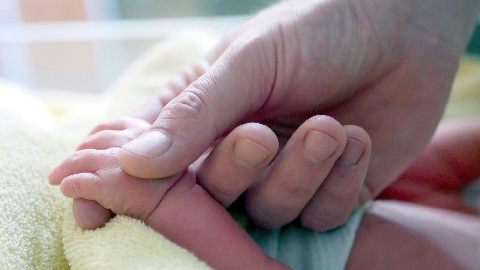 Vater Timo Meyer hält die Hand der kleinen Lia-Sophie Marina, deren Geburt die 1000. in diesem Jahr im Auricher Krankenhaus war. Foto: Zentralklinik Ostfriesische Meere