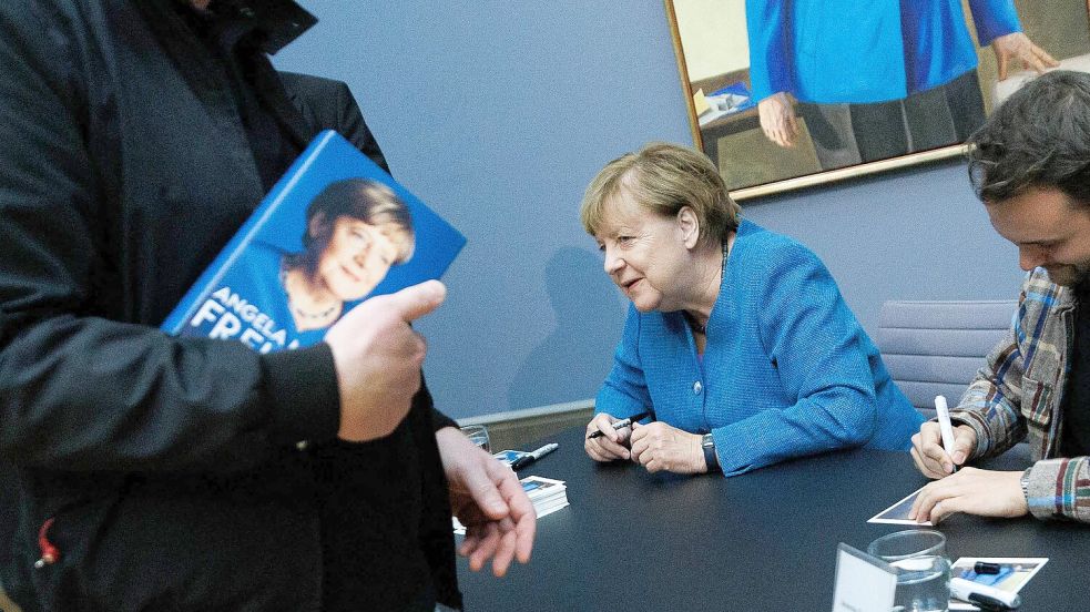 Vor Kurzem signierte Altkanzlerin Angela Merkel noch im Bode-Museum in Berlin Kunstpostkarten. Jetzt kommt sie auch nach Emden. Foto: Carsten Koall/dpa