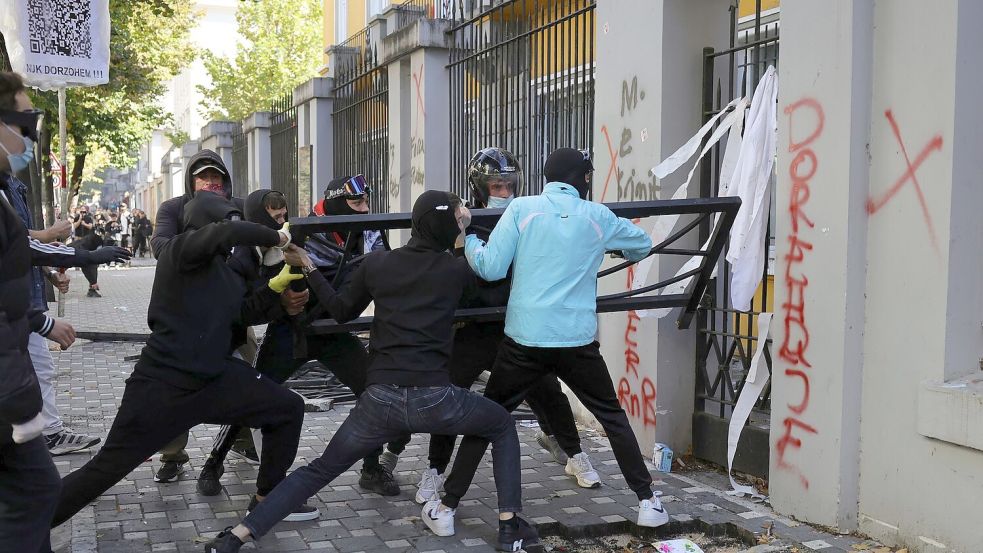 Vermummte Demonstranten versuchten, ein Tor am Bildungsministerium zu durchbrechen. (Archivbild) Foto: Hameraldi Agolli/AP/dpa