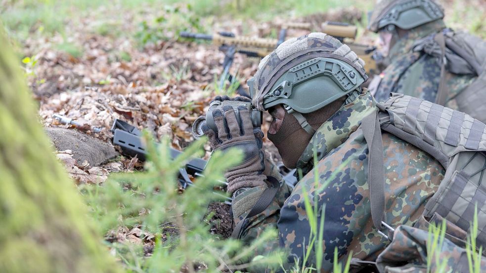 Während der Basisausbildung beobachten Rekruten im Gras liegend das Gelände und sichern ihre Position. Foto: André Havergo