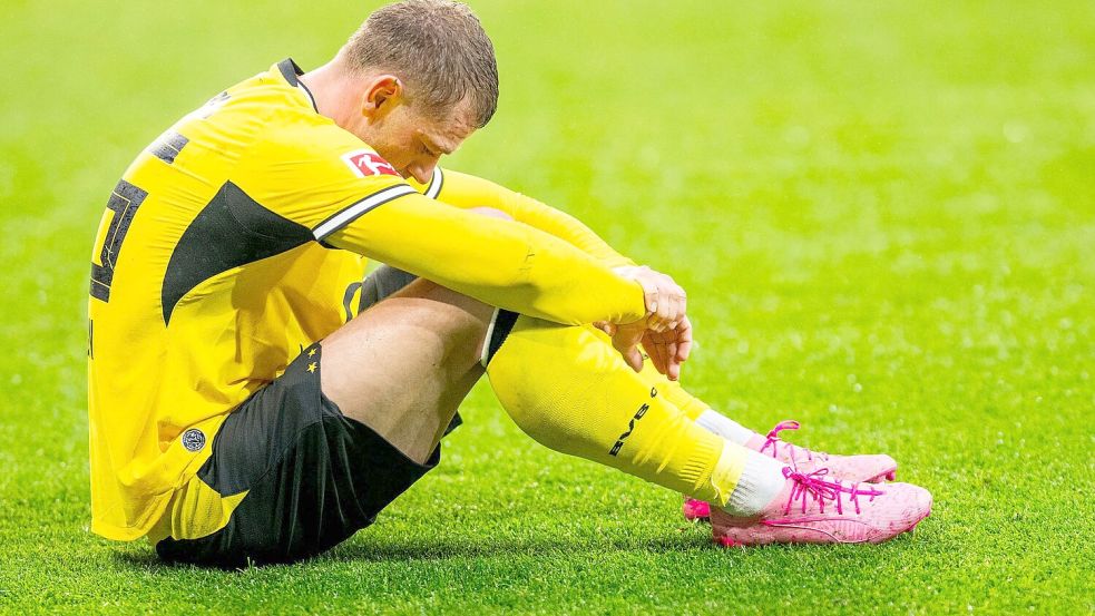 BVB-Profi Julian Ryerson saß nach dem nächsten Rückschlag enttäuscht auf dem Rasen. Foto: Julius Frick/dpa