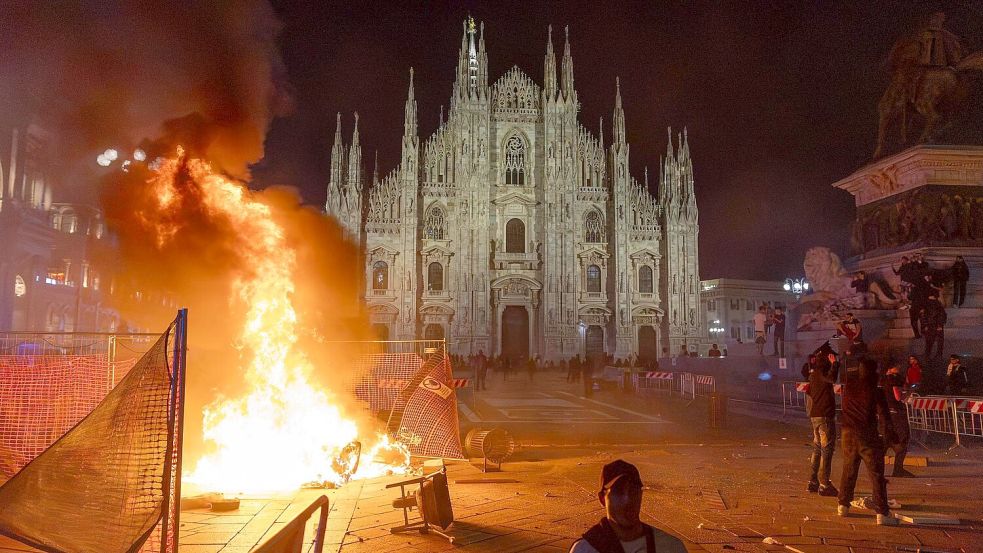 Vor dem Mailänder Dom brannte am Samstagabend ein Feuer.  Foto: Stefano Porta/LaPresse/AP/dpa