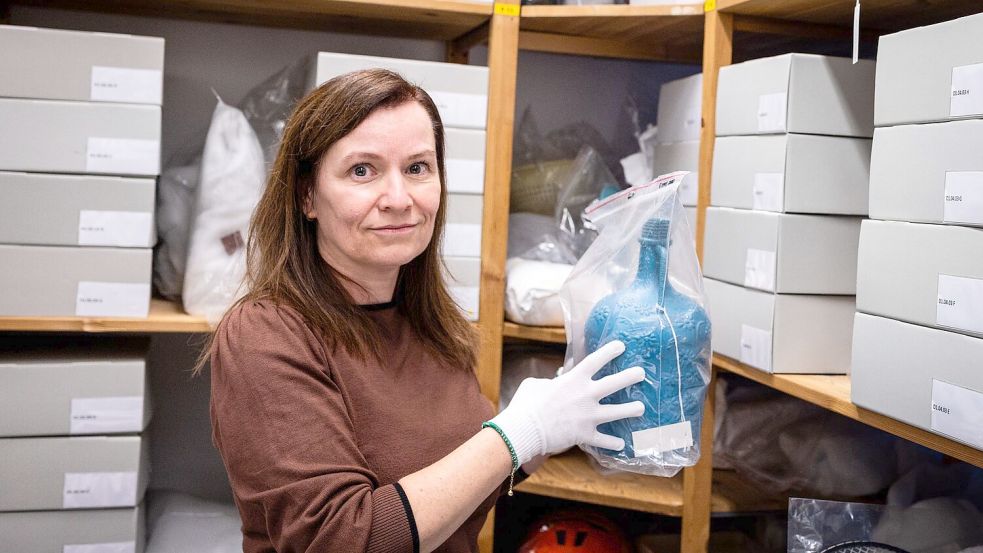 Bengü Kocatürk-Schuster vom Dokumentationszentrum und Museum über die Migration in Deutschland (DOMiD) zeigt eine Trinkflasche, die von Türken einst auf ihre erste Reise nach Deutschland mitgenommen wurde. Foto: Christian Knieps/dpa